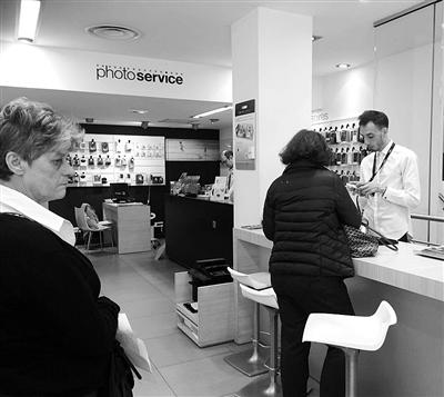 巴黎某通讯运营商门店内,顾客正在向工作人员咨询产品使用事项.